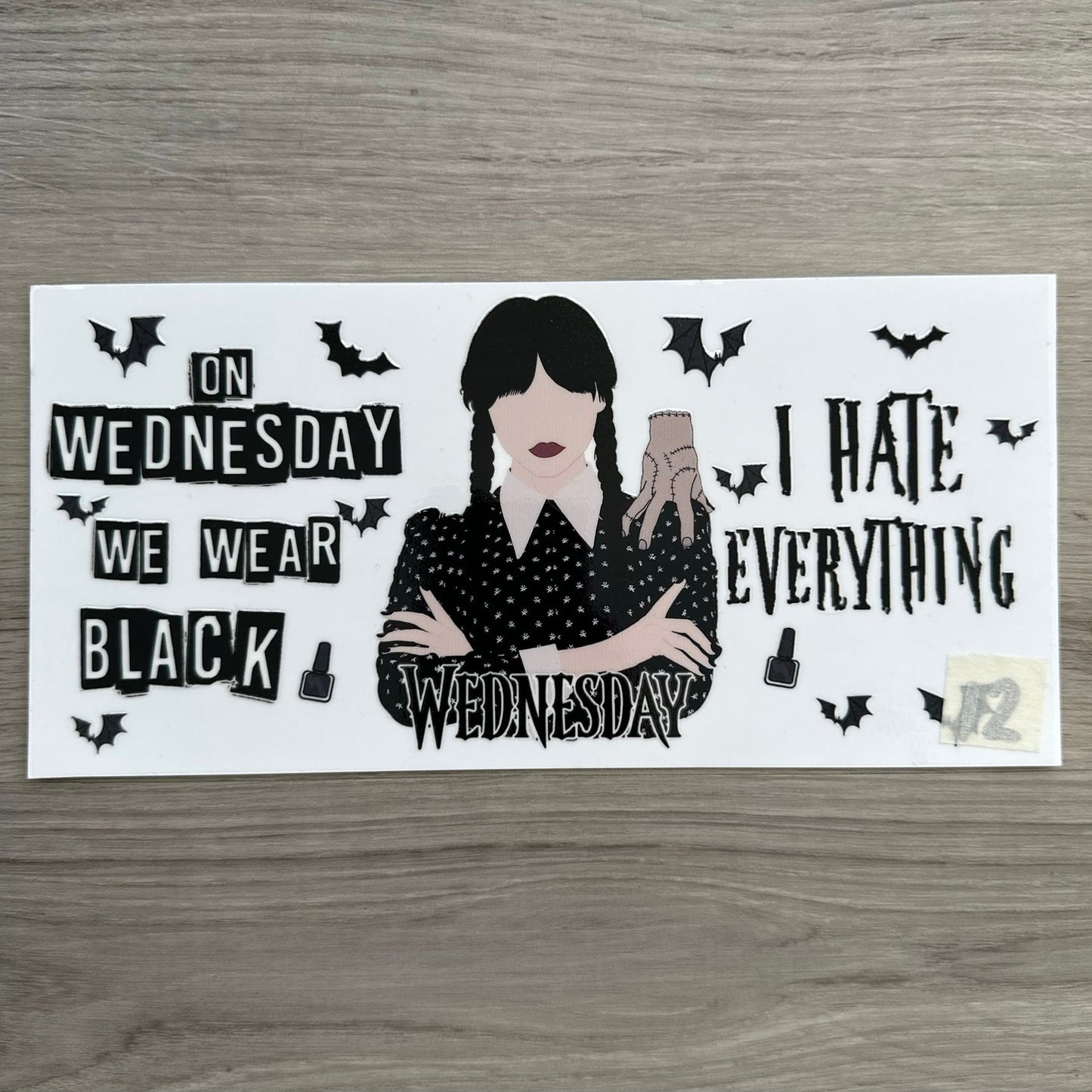 A Wednesday wrap with wednesday and thing in the middle. Then either side is "I hate everything" and "on wednesday we wear black"