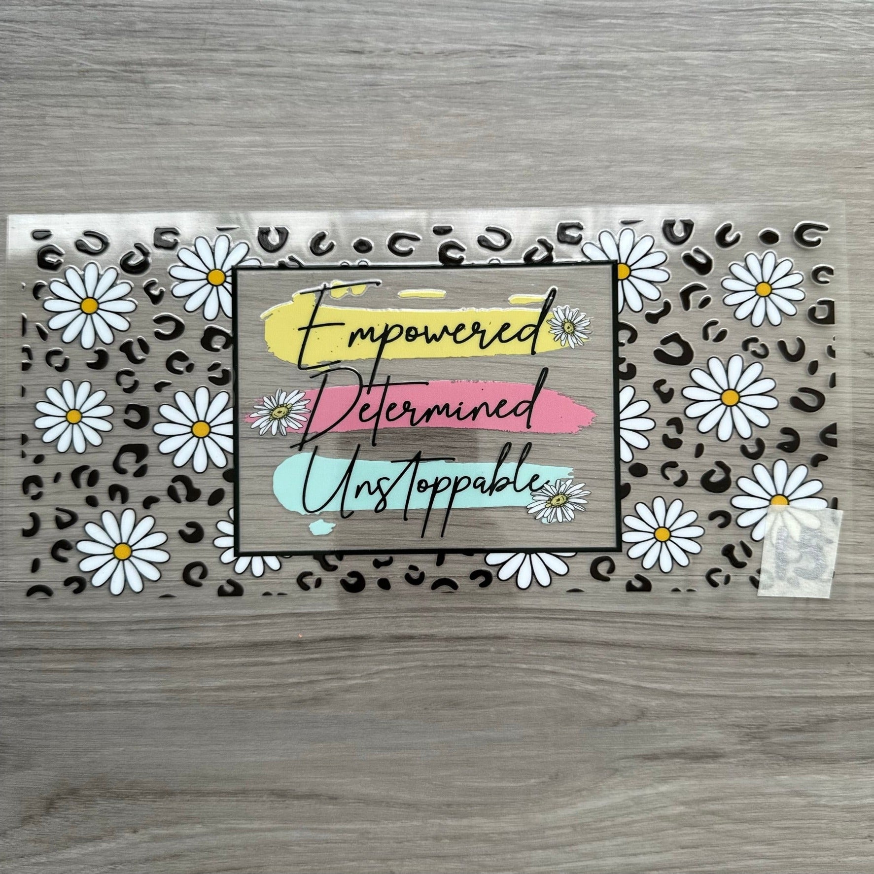 "Empowered, Determined, Unstoppable" in the middle, with cheetah print and daisys around