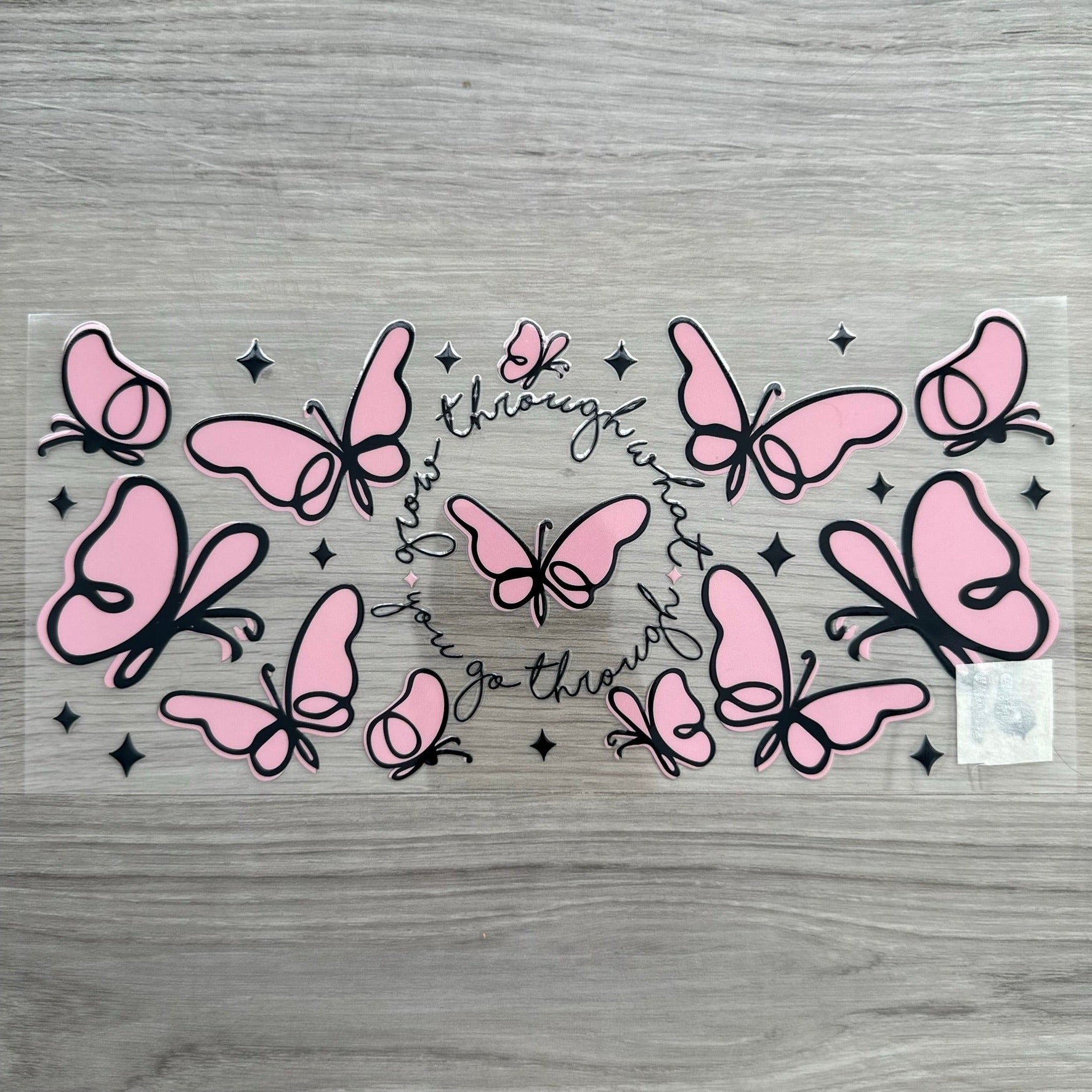 "grow through what you go through" with pink butterflies and black sparkles around it