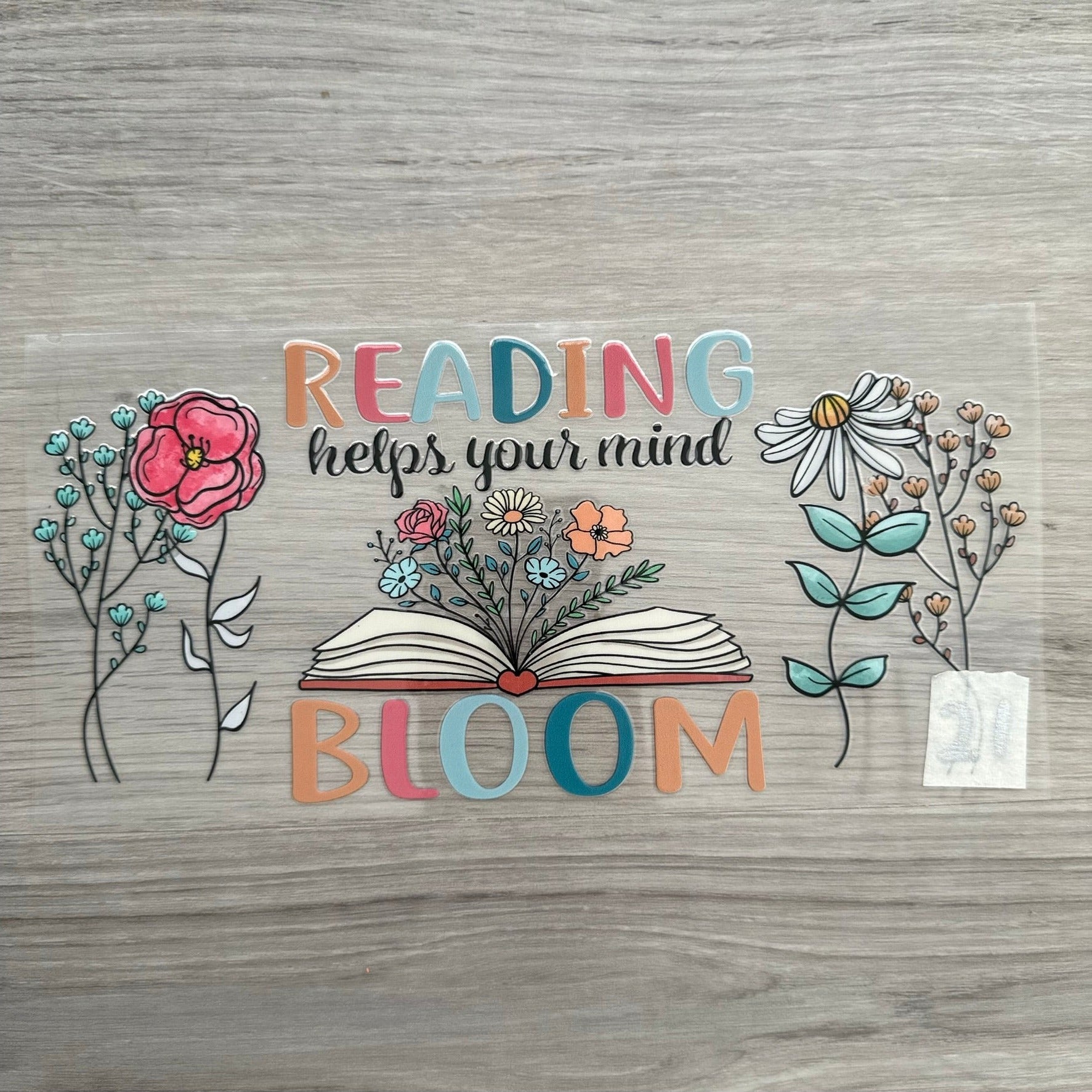 A quote that says "reading keeps your mind bloom" with flowers either side of the quote, and a book with flowers sprouting out of it